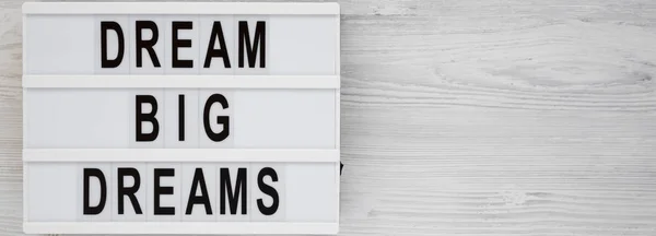 'Dream big dreams' words on a lightbox on a white wooden backgro