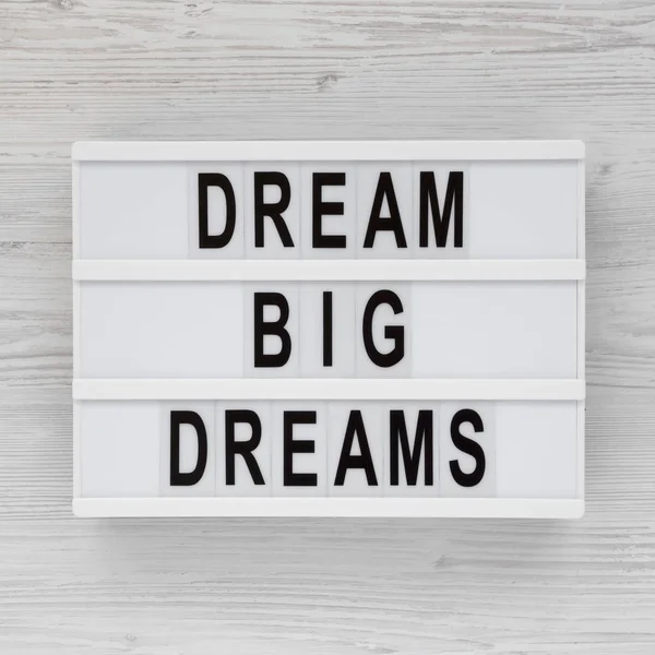 'Dream big dreams' words on a lightbox on a white wooden surface