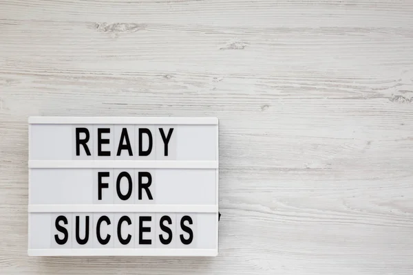 "Ready for success" steht auf einem Leuchtkasten auf einer weißen Holzplatte — Stockfoto