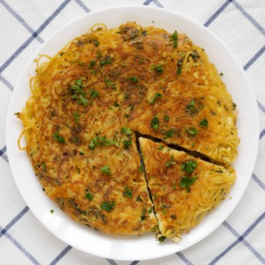 Beyaz tabakta ev yapımı spagetti omleti, üst manzara. Düz yatıyordu