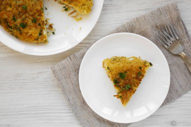 Beyaz ahşap bir tabakta ev yapımı spagetti omleti.