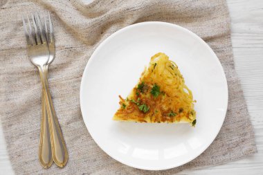 Beyaz ahşap bir tabakta ev yapımı spagetti omleti.
