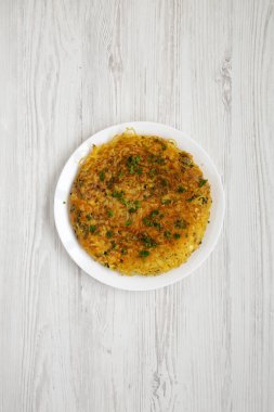 Beyaz ahşap bir tabakta ev yapımı spagetti omleti.
