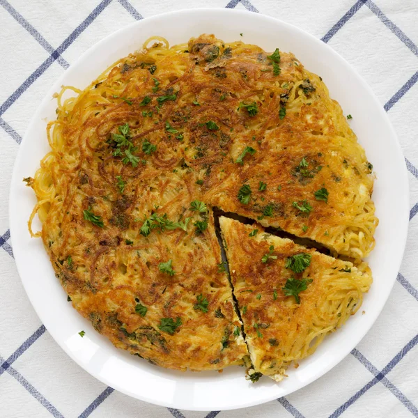 Tortilla de espaguetis casera en un plato blanco, vista superior. Puesta plana — Foto de Stock