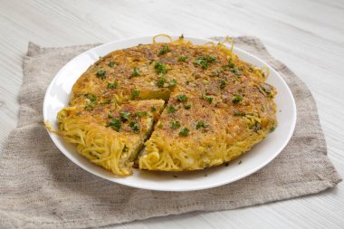 Beyaz tabakta ev yapımı spagetti omleti, yan manzara. Kapat.