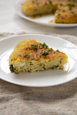 Beyaz tabakta ev yapımı spagetti omleti, yan manzara. Kapat.