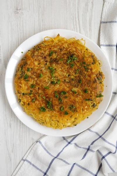 Tortilla de espaguetis casera en un plato blanco sobre madera blanca b — Foto de Stock