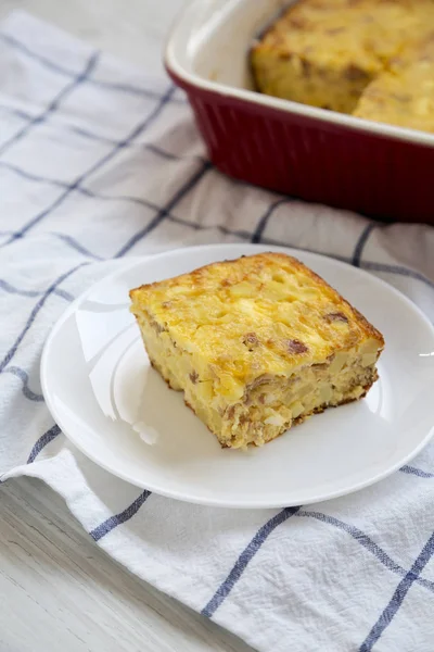 Homemade Cheesy Amish Breakfast Casserole on a white wooden back — Stock Photo, Image