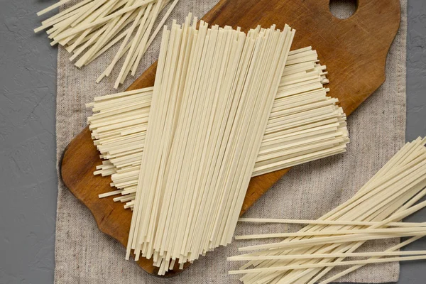 Fideos Ramen blancos secos sin cocer sobre un tablero rústico sobre gris sur —  Fotos de Stock