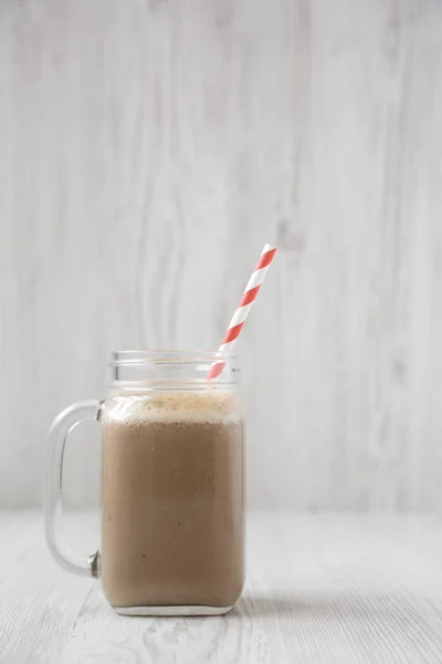 Glasburk mugg fylld med kaffe, havre och banan smoothie på en w — Stockfoto