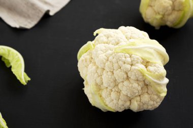 Siyah bir yüzey üzerinde çiğ Karnabahar Kafaları, yan görüş. Yakın plan.. 