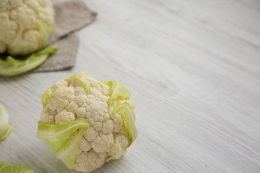 Beyaz ahşap bir yüzey üzerinde çiğ Karnabahar Kafa, yan görüş. Anlaşıldı. 