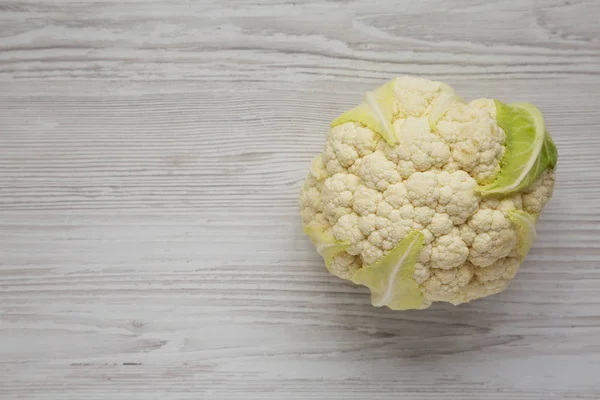 Raw Cauliflower Head on a white wooden background, overhead view — Stock Photo, Image