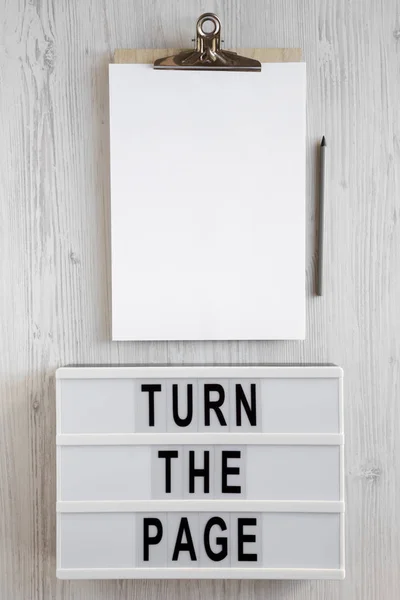 \'Turn the page\' words on a modern board, clipboard with blank sh