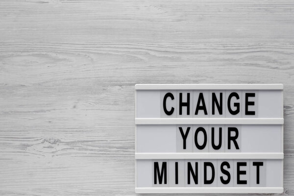 Top view, 'Change your mindset' words on a lightbox on a white w