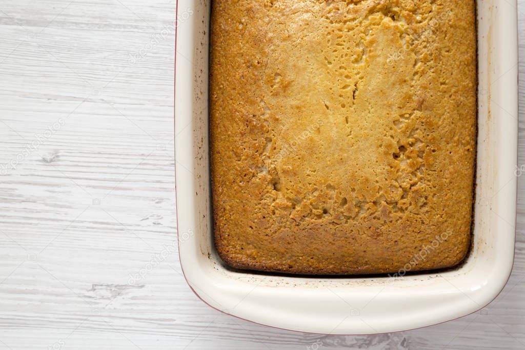 Homemade sweet Cornbread in a dish over white wooden surface, to