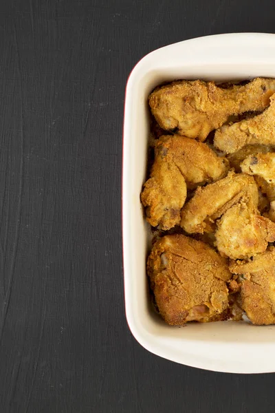 Вкусная домашняя печь запеченный жареный цыпленок в блюде над черным — стоковое фото