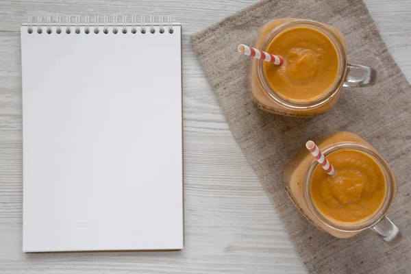 Bovenaanzicht Zelfgemaakte Pompoen Smoothie Glazen Potten Witte Houten Achtergrond Plat — Stockfoto