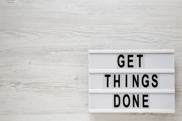 'Get things done' words on a modern board on a white wooden surf