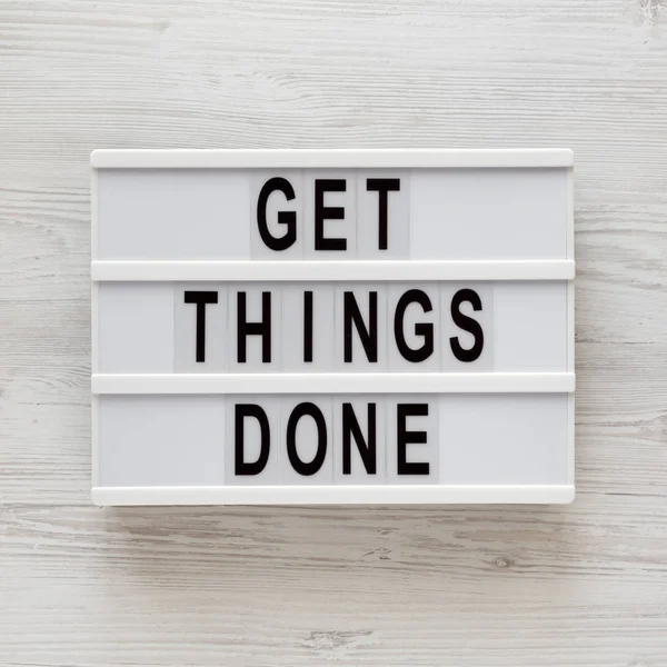 \'Get things done\' words on a modern board on a white wooden back