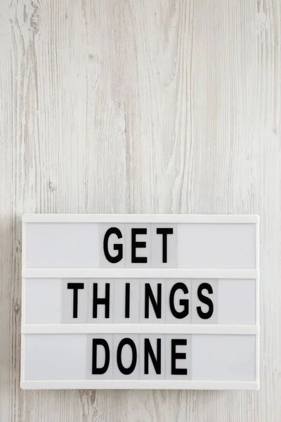 'Get things done' words on a lightbox on a white wooden backgrou