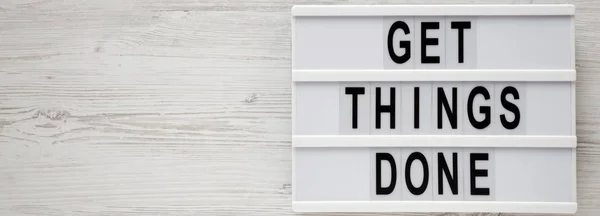 \'Get things done\' words on a modern board on a white wooden back