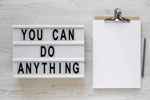 'You can do anything' words on a lightbox, clipboard with blank