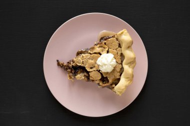 Pembe bir tabakta ev yapımı çikolatalı cevizli turta.