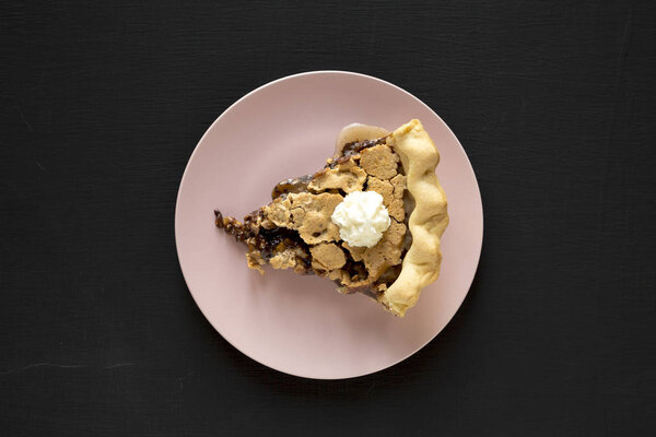 A piece of homemade Chocolate Walnut Derby Pie on a pink plate o