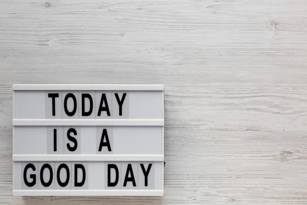 \'Today is a good day\' words on a lightbox on a white wooden back