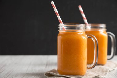 Cam kavanozlarda ev yapımı Mango Havuç Smoothie, yan görüş. Sp Kopyala