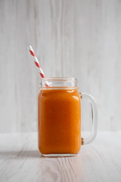 Hemlagad Mango morot smoothie i en glasburk mugg över vit woo — Stockfoto