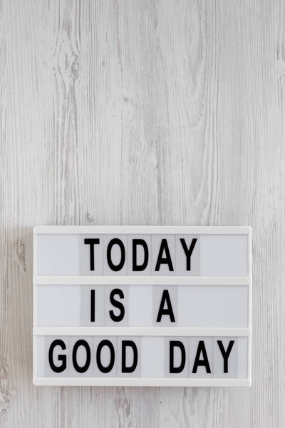'Today is a good day' words on a lightbox on a white wooden back