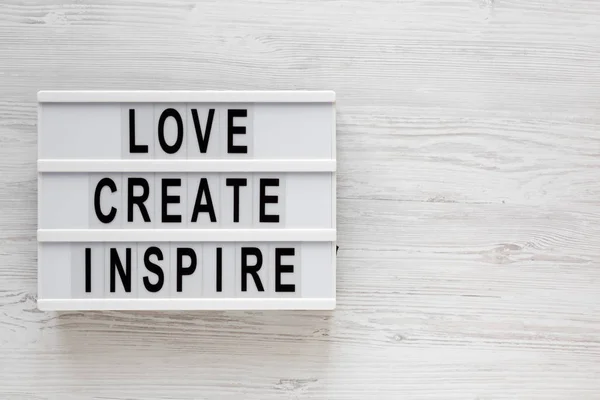 'Love create inspiration 'mots sur une lightbox sur un dos en bois blanc — Photo