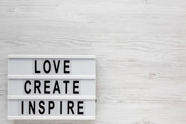 'Love create inspire' words on a modern board on a white wooden — 스톡 사진