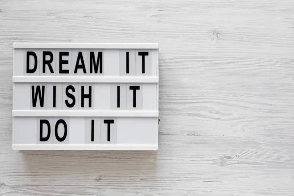 \'Dream it, wish it, do it\' words on a modern board on a white wo