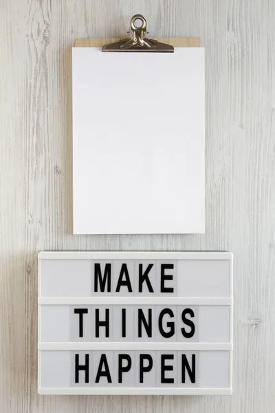 \'Make things happen\' words on a modern board, clipboard with bla