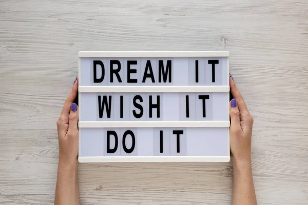 Feamle mains tenir conseil moderne avec 'Dream it, wish it, do it' w — Photo