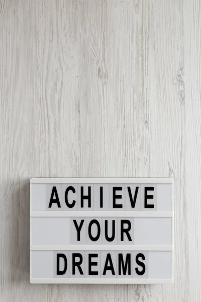 "Erreichen Sie Ihre Träume" steht auf einem modernen Brett auf weißem Holz. — Stockfoto