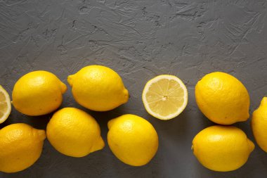 Gri arka planda taze, olgun, sarı organik limonlar, üst manzara. F