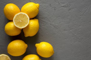 Gri arka planda taze, olgun, sarı organik limonlar, üst manzara. F