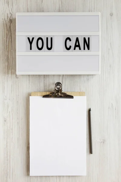 Mots "vous pouvez" sur une lightbox, presse-papiers avec feuille vierge de pap — Photo