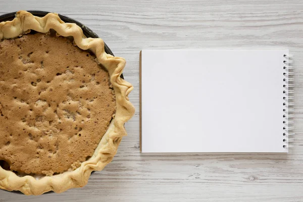 Tarte Derby aux noix au chocolat maison, bloc-notes vierge sur un wo blanc — Photo