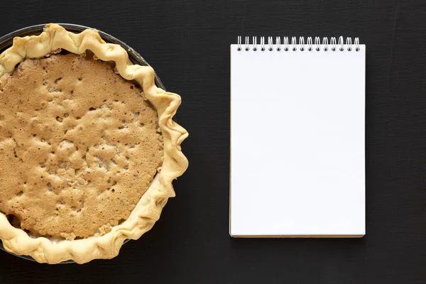 Tarte Derby aux noix au chocolat maison, bloc-notes vierge sur une ba noire — Photo