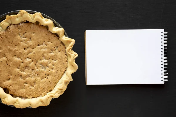 Tarte Derby aux noix au chocolat maison, cahier vierge sur un s noir — Photo