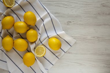 Beyaz ahşap arka planda olgun sarı organik limonlar.