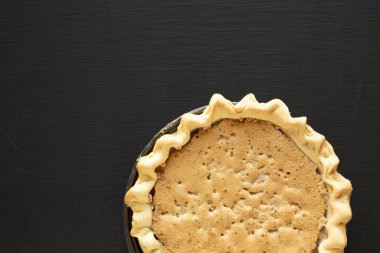 Ev yapımı çikolatalı cevizli turta. Siyah bir yüzey, üst manzara.