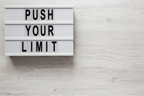 'Push your limit' words on a modern board on a white wooden back — Stock Photo, Image