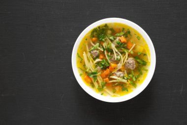 Siyah bir yüzey üzerinde beyaz bir kâsede ev yapımı Sopa a a La Minuta...