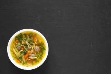 Siyah arka planda beyaz bir kâsede ev yapımı Sopa La Minuta.,